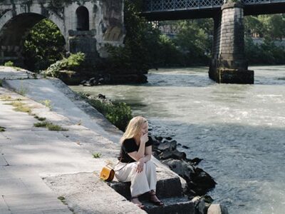 Ingeborg Bachmann (Sandra Hüller) sitzt am Ufer des Tiber und liest eine ihrer Notizen. (© Elliott Kreyenberg)